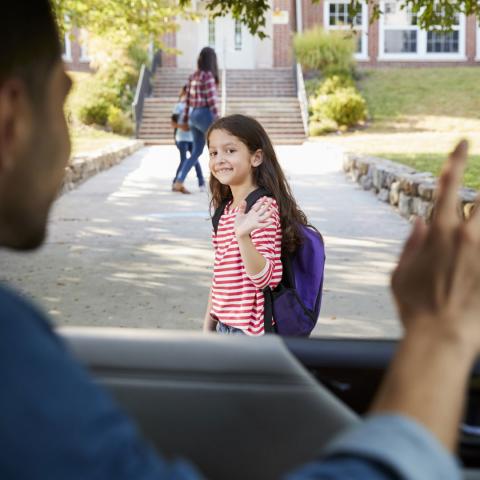 Girl waves at dad as she walks away to school